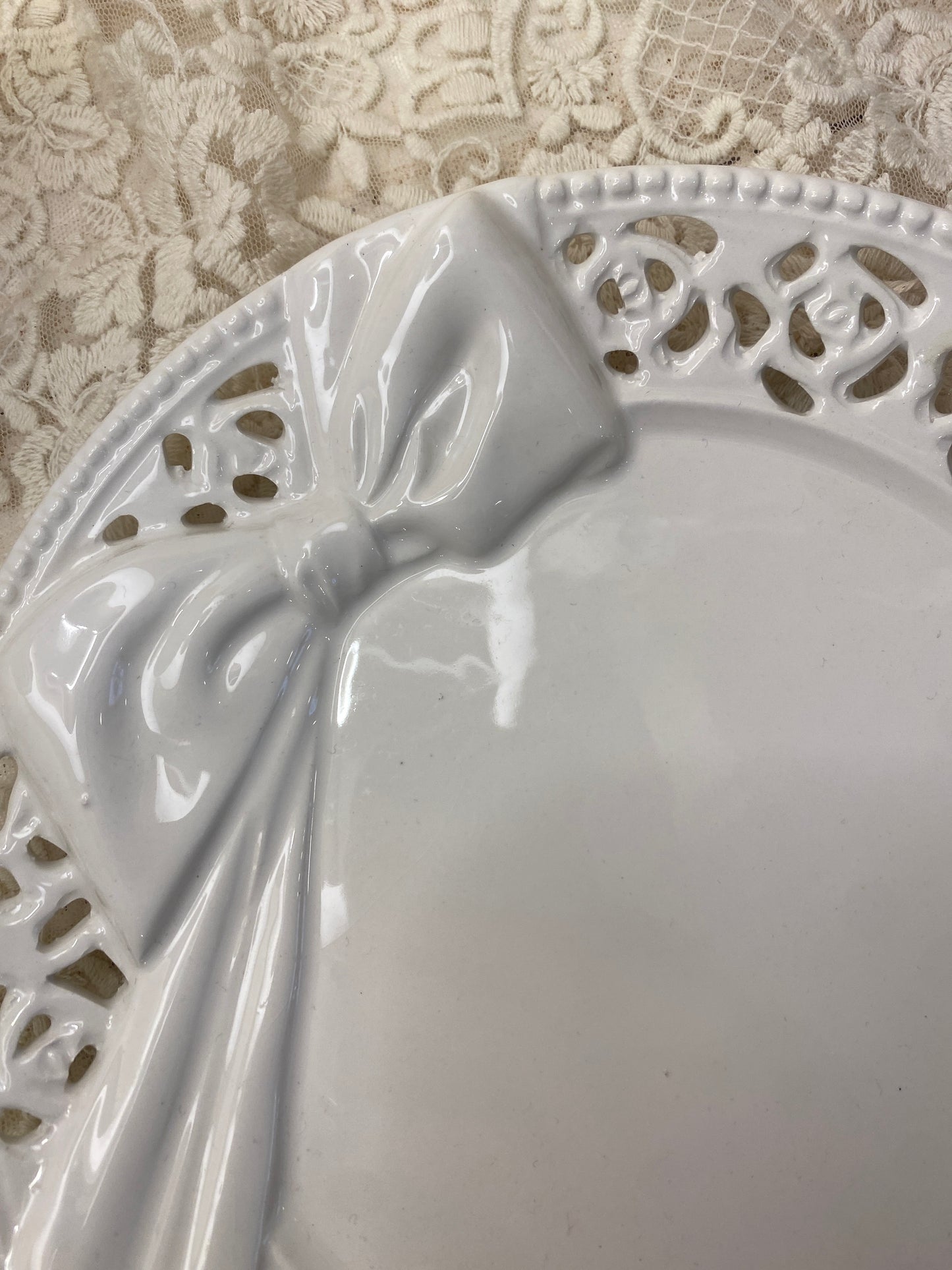 Piatto traforato in ceramica con decoro con fiocco 20x20cm